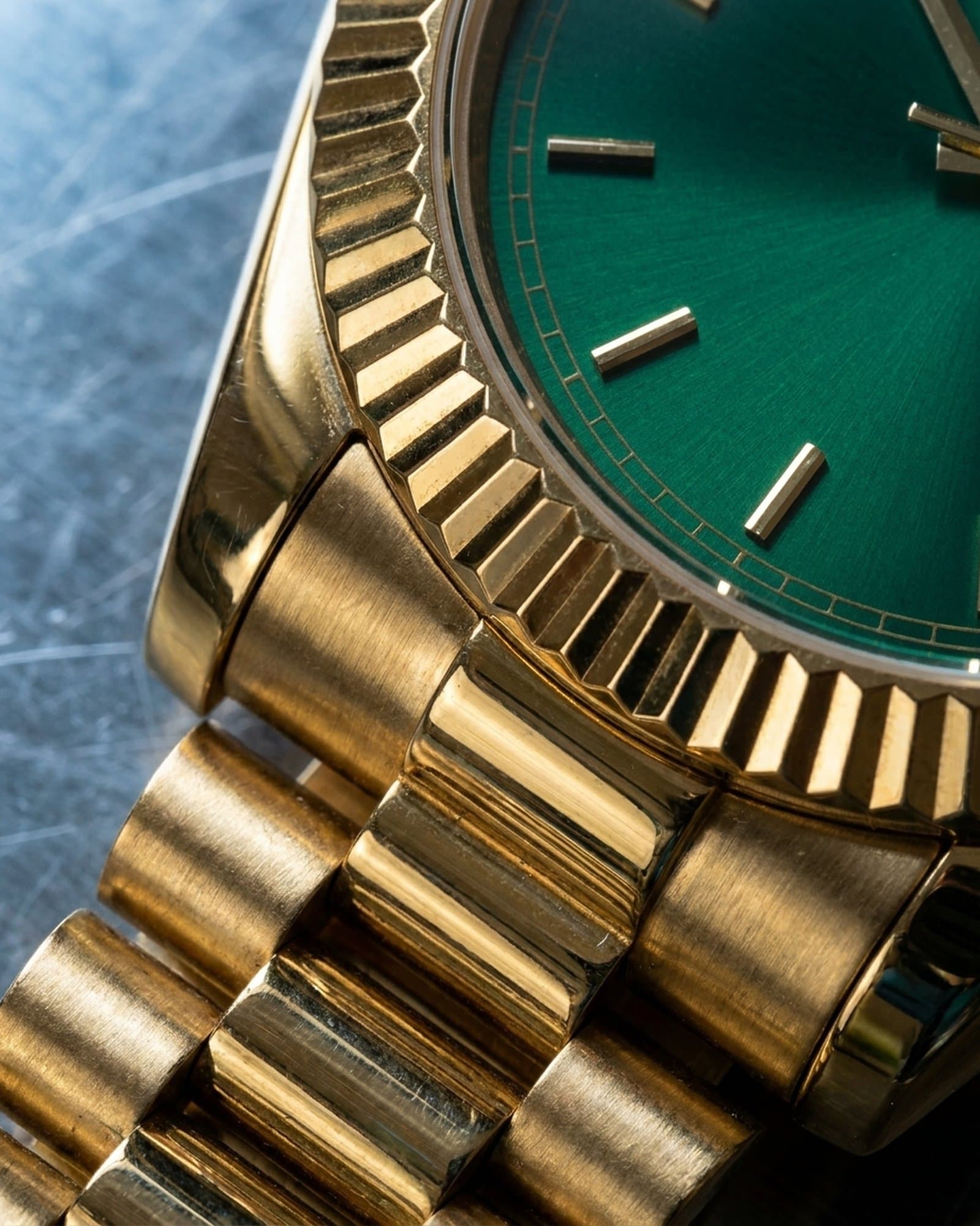 Close-up of the fluted gold bezel beside the green dial